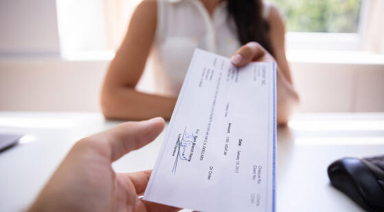 Mujer entregando un cheque firmado