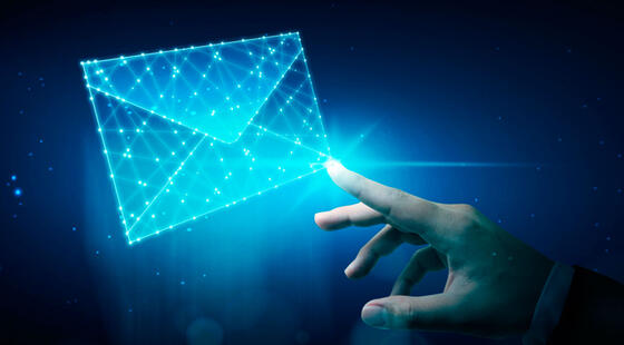 Mano con el dedo índice extendido tocando lo que simula ser un holograma representando un sobre