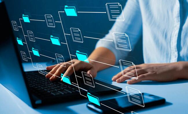 Manos de hombre sentado frente a un ordenador manipulando su teclado